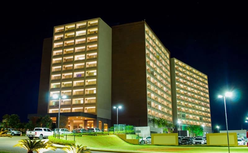 Fachada do Hot Beach Resort com iluminação noturna.