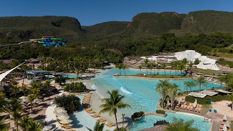 Piscina natural de um fervedouro com águas de cor azul turquesa intensa, cercada por vegetação.