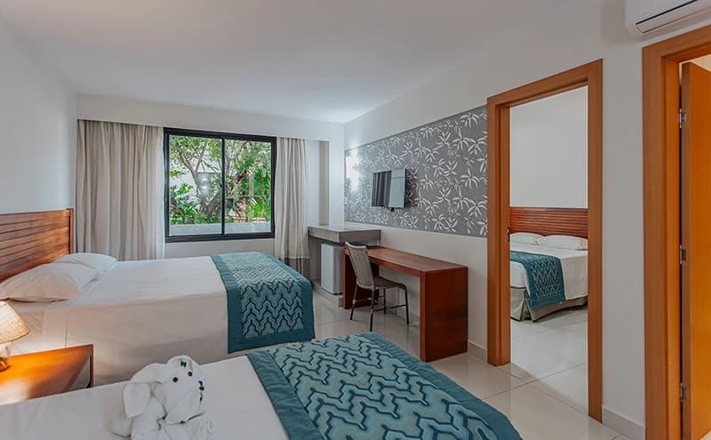 Quarto com duas camas de solteiro e decoração em tons de azul.