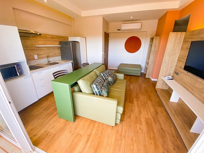 Interior de um apartamento decorado do Hot Beach Suites, mostrando a sala e cozinha