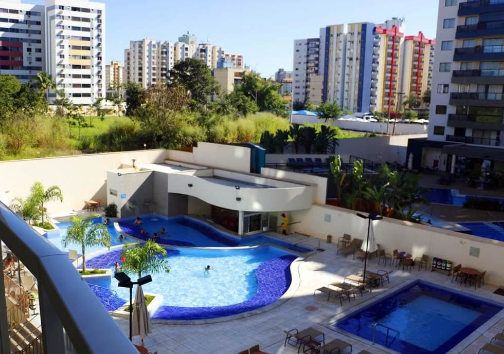 Piscina principal do hotel com espreguiçadeiras ao redor.