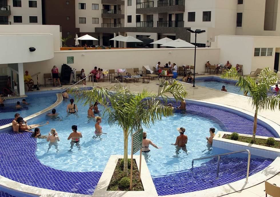 Área de piscinas termais com bar molhado ao fundo.