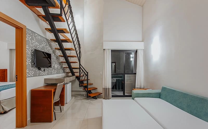 Interior de um apartamento espaçoso do Hotel Luupi com camas e uma sala de estar