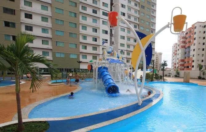 Piscina principal com bar molhado e hóspedes aproveitando.