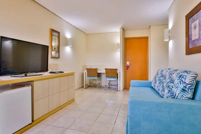 Apartamento com sala de estar e uma mini cozinha.