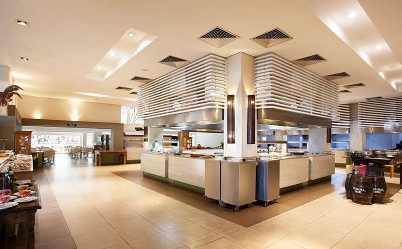 Cozinha industrial do hotel com bancadas e equipamentos em aço inox.