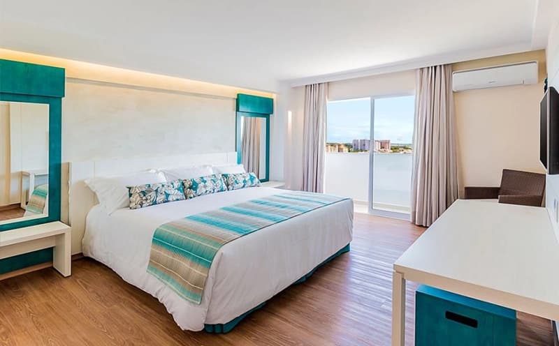 Quarto com cama de casal e decoração com detalhes em azul.