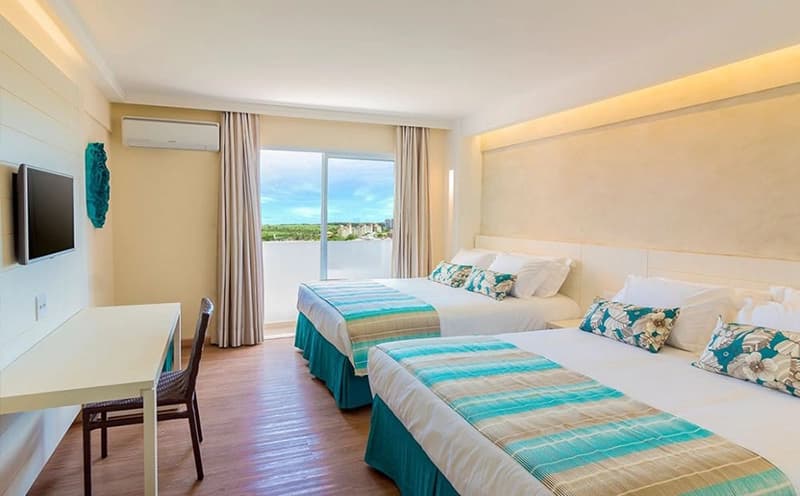 Quarto com duas camas de solteiro e decoração em tons de verde.