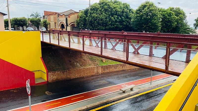 Ponte de pedestres com estrutura colorida em amarelo e vermelho em Olímpia