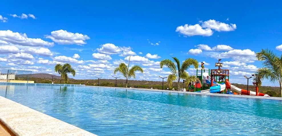 Família se divertindo na borda da piscina de ondas com areia artificial.
