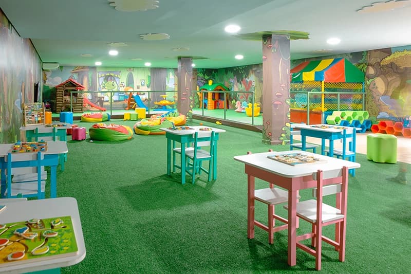 Visão ampla da brinquedoteca do hotel, equipada com diversos brinquedos.