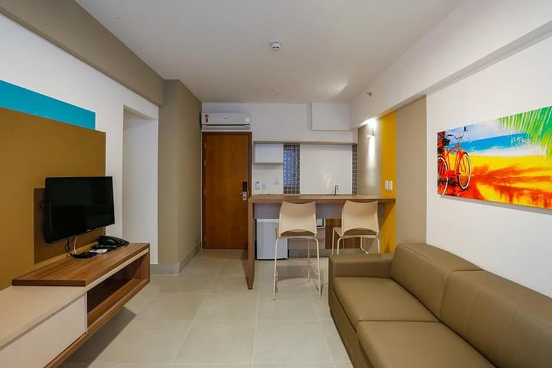 Sala de estar de um apartamento com sofá e televisão.