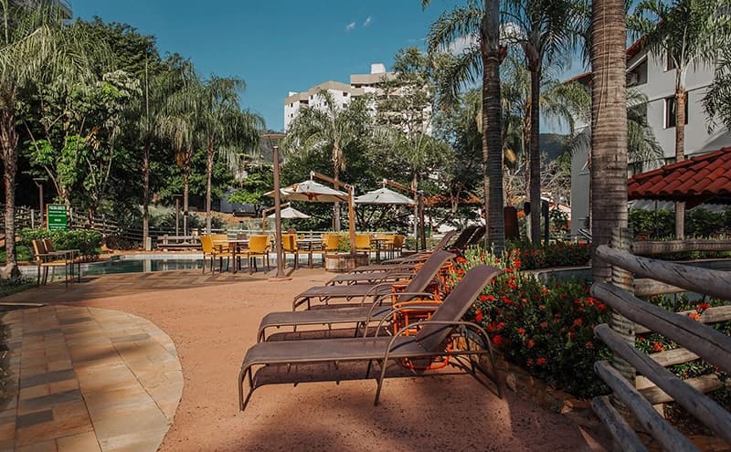 Espreguiçadeiras posicionadas para os hóspedes na beira da piscina.
