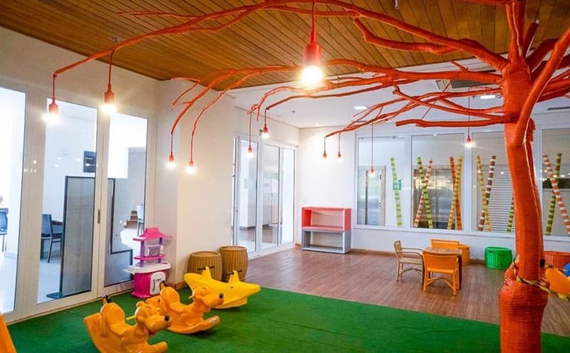 Espaço kids interno e colorido com brinquedos educativos.