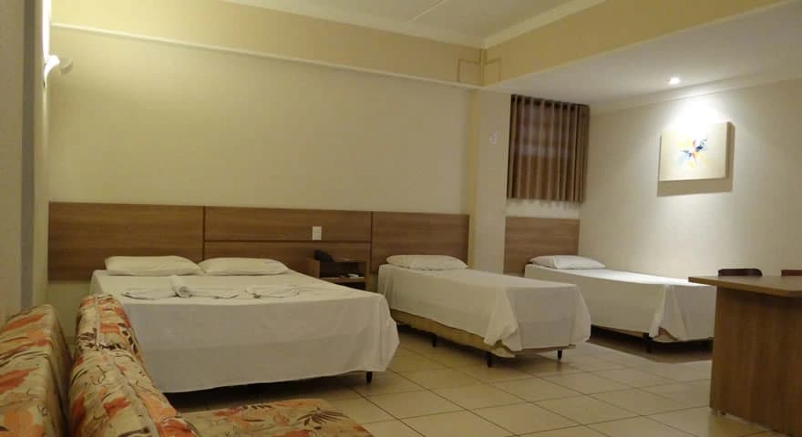 Área externa do hotel com jardim bem cuidado.