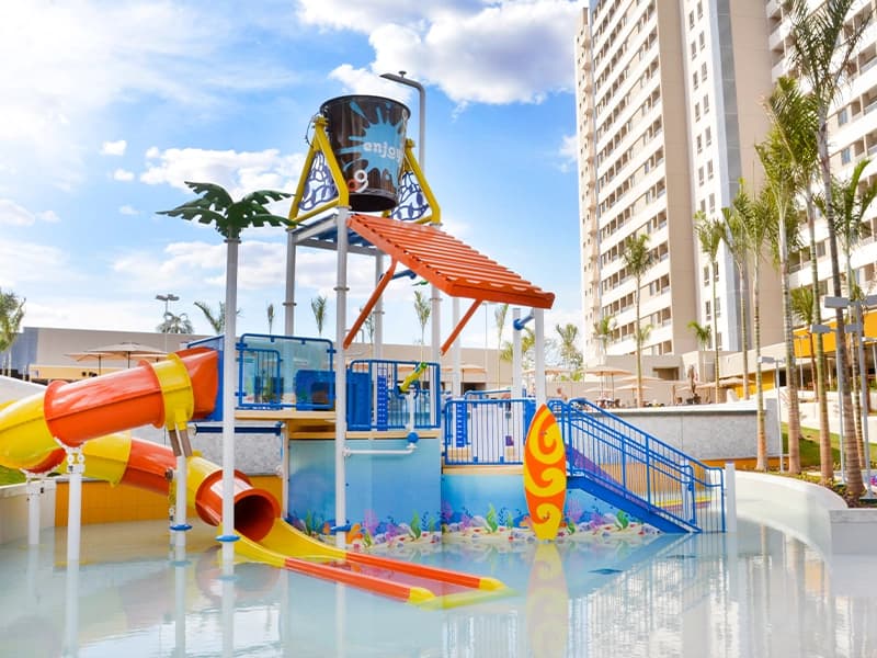 Piscina infantil com toboáguas em frente ao prédio do resort.