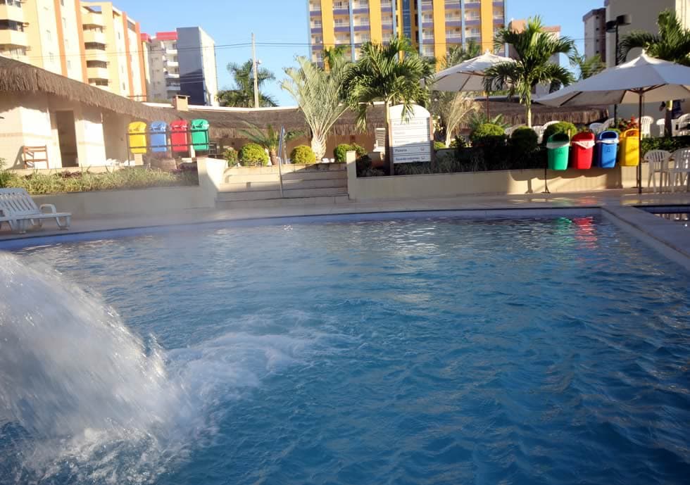 Bar molhado com pessoas sentadas em bancos dentro da piscina.