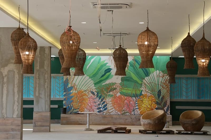 Ambiente do restaurante com decoração de folhagens na parede.