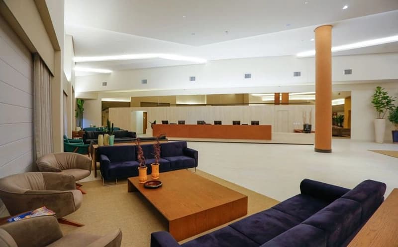 Sala de estar de um apartamento com sofá e vista para a cozinha.