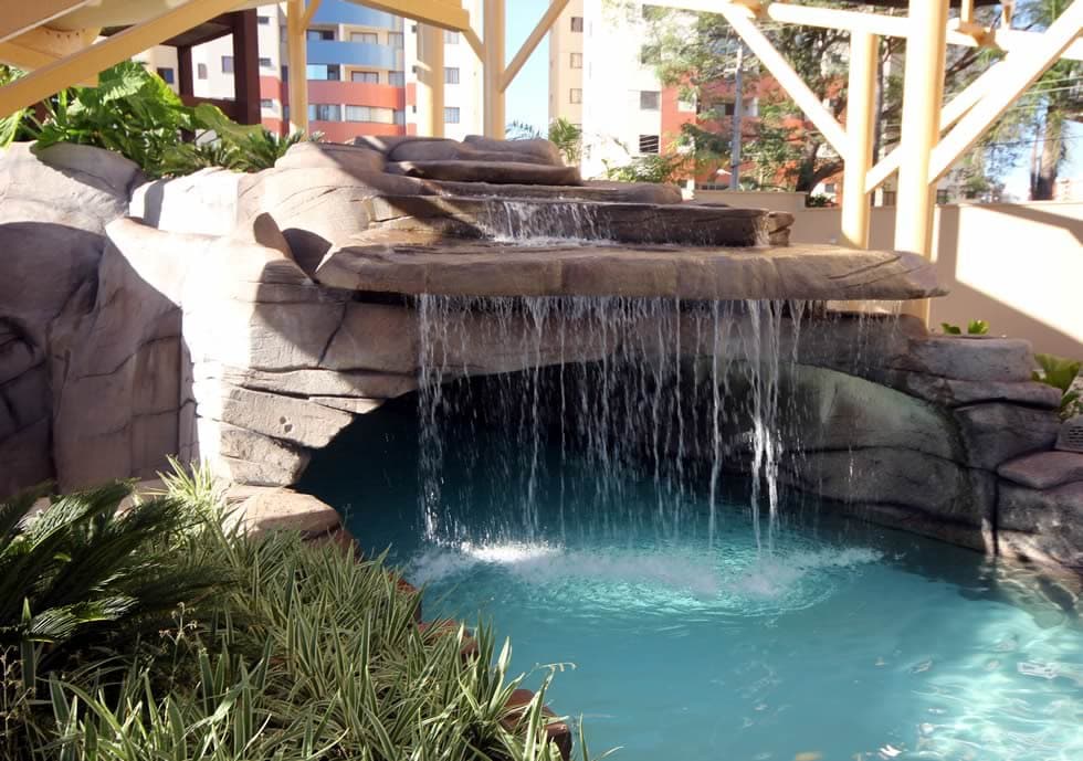 Rio lento com visitantes em boias passando por baixo de uma ponte.