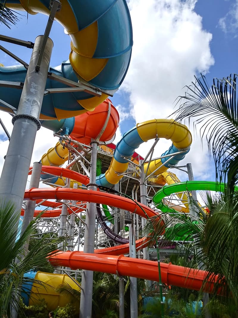 Pai jogando o filho para o alto dentro de uma piscina, em um momento de diversão.