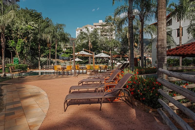 Ampla área de lazer com espreguiçadeiras ao redor da piscina.