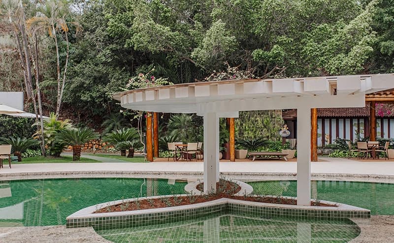 Outro ângulo da piscina ornamental com passarela branca.