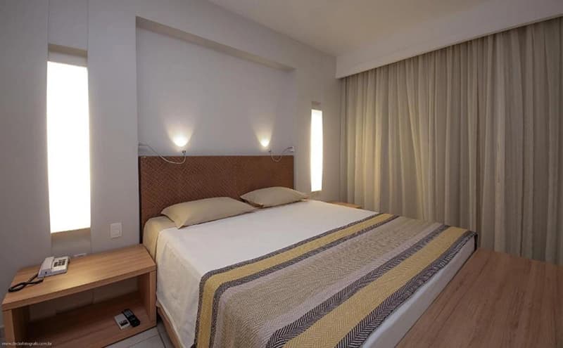 Quarto de hotel com uma cama de casal e uma de solteiro.
