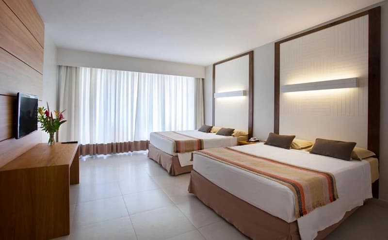 Suíte de hotel espaçosa com cama e sala de estar integrada.