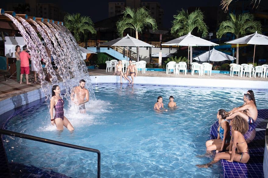 Adultos e crianças na piscina de ondas com boias.