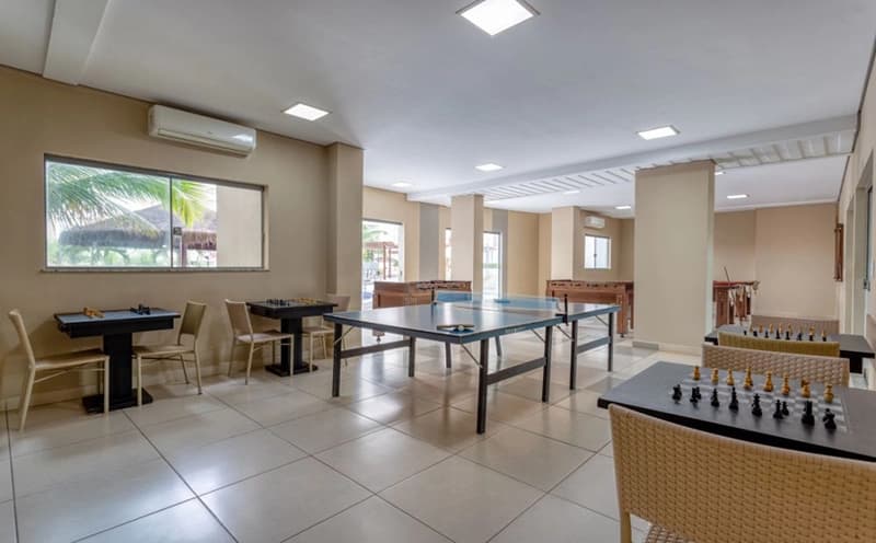 Cafeteria ou área de alimentação do hotel com mesas e balcão ao fundo.