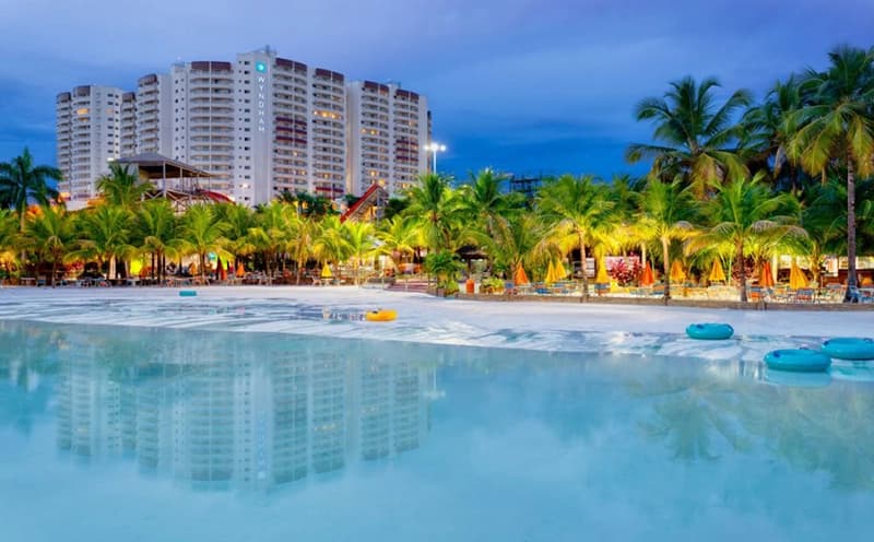 Piscina de águas claras com hóspedes aproveitando o dia.
