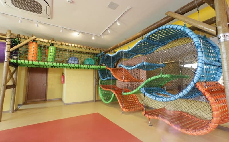 Espaço kids do hotel com brinquedo de escalada e túneis.