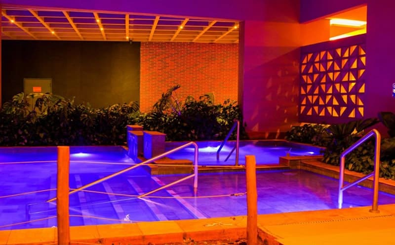 Palco para apresentações e eventos com iluminação roxa e azul.