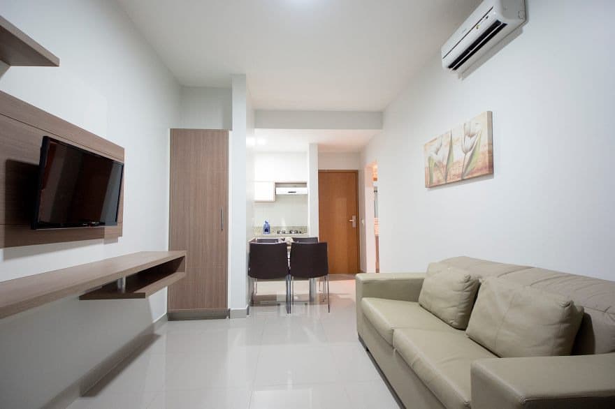 Varanda do apartamento com mesa, cadeiras e vista.