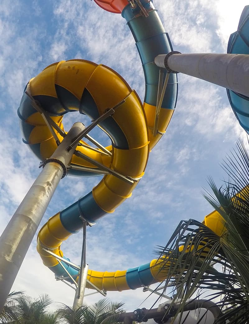 Pessoa deitada em uma prancha na atração de surf artificial do parque.