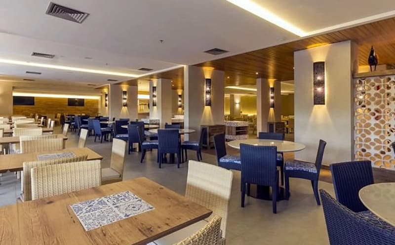 Restaurante ou salão de café da manhã com mesas e cadeiras azuis.