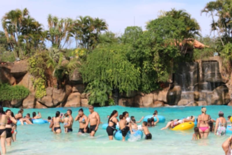 Close de uma boia de borracha amarela e azul flutuando na água da piscina.