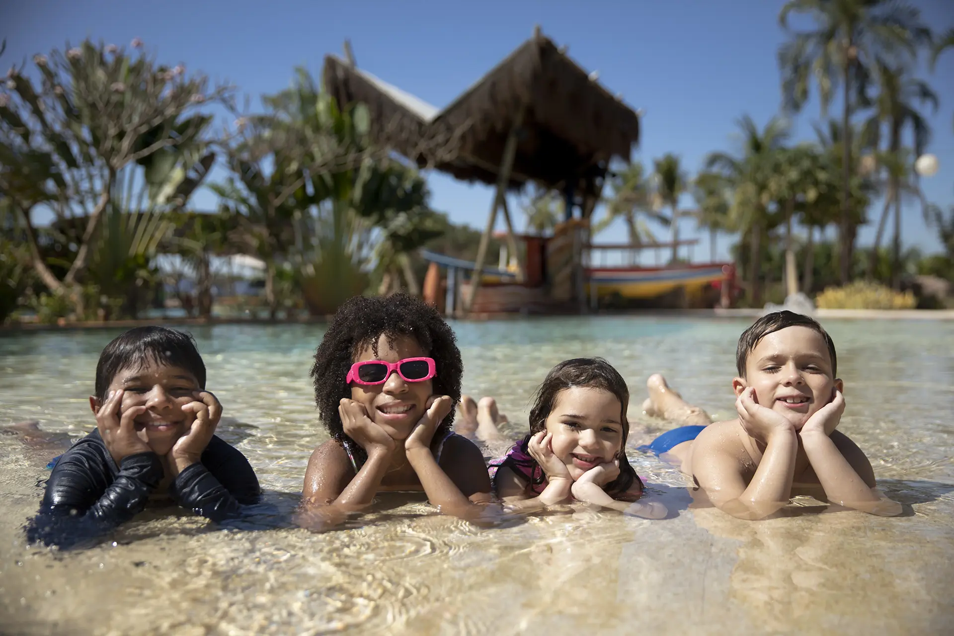 Grupo de amigos posando para foto na areia da praia do Hot Beach.