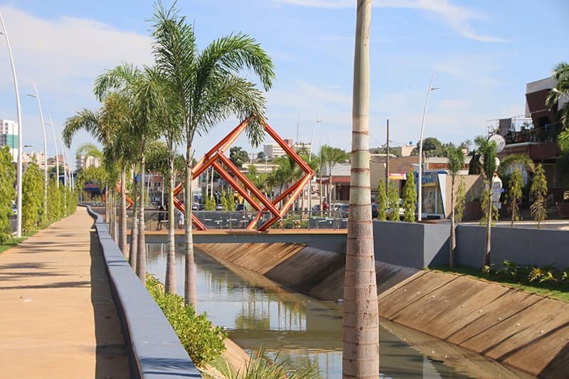 Calçadão com coqueiros e espelho d'água no complexo Hot Beach Resorts