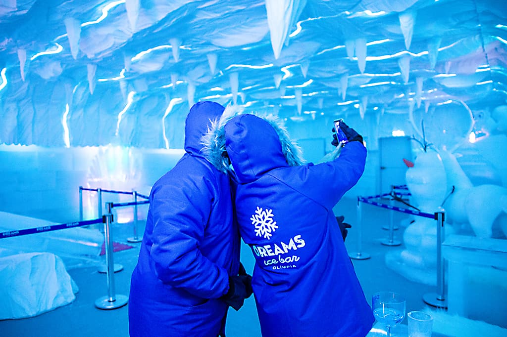 Família posando para foto em um trono de gelo no Dreams Ice Bar Olímpia.