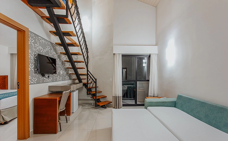 Interior de um apartamento espaçoso do Hotel Luupi com camas e uma sala de estar