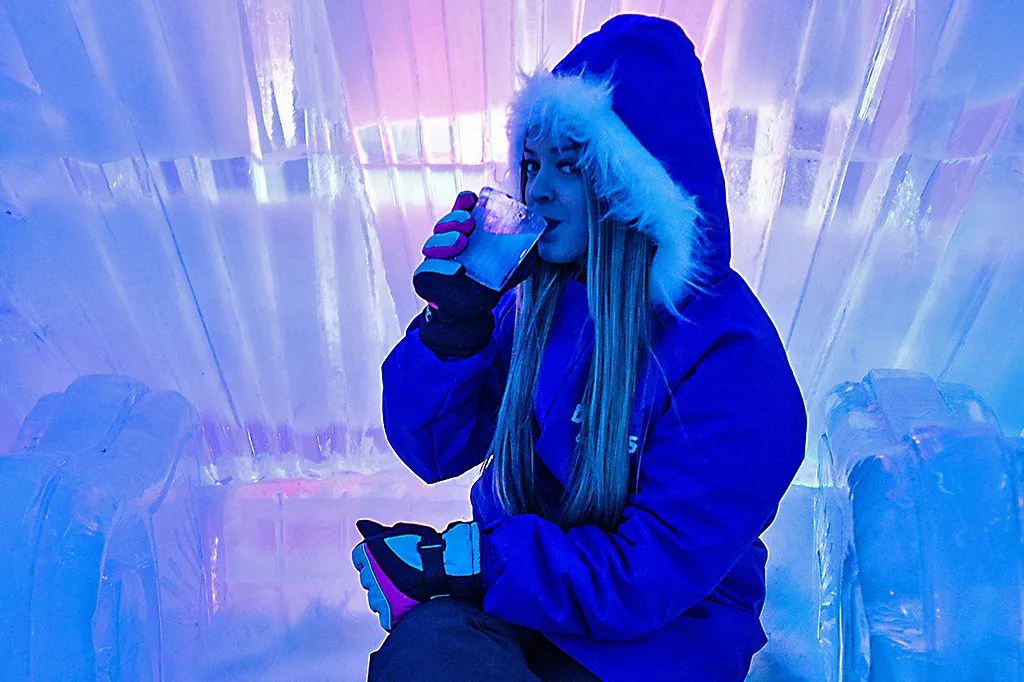 Pessoas brindando com copos de gelo coloridos dentro do Dreams Ice Bar.