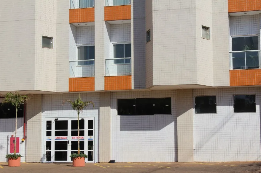 Área externa do hotel com estacionamento.