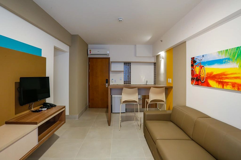 Sala de estar de um apartamento com sofá e televisão.