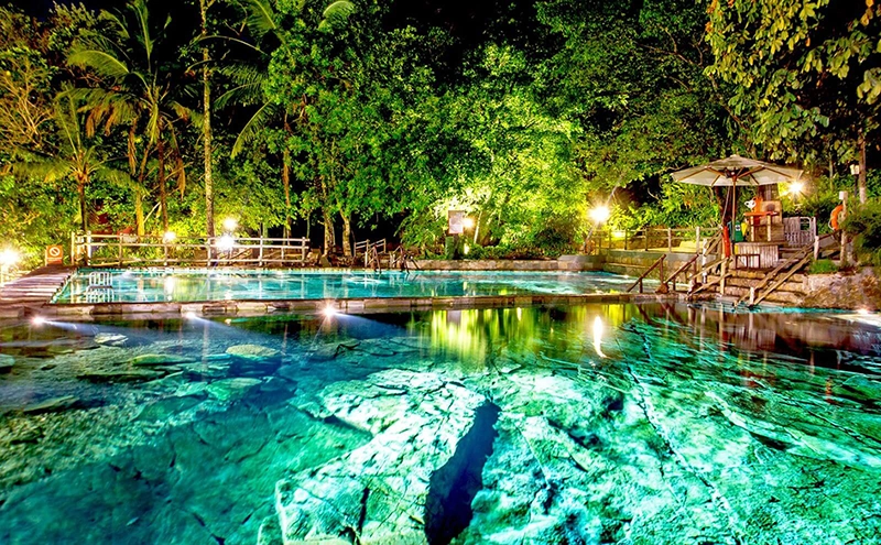 Piscina natural do Parque das Fontes com iluminação subaquática durante a noite