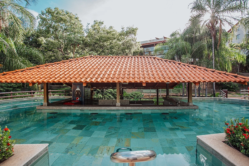 Bar molhado com estrutura de madeira localizado dentro da piscina.