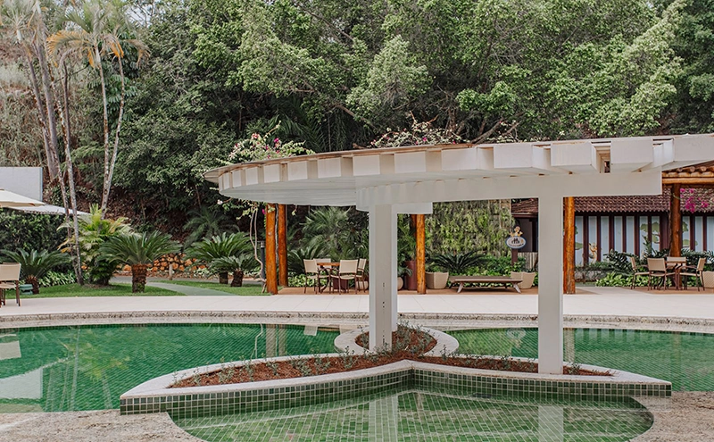 Outro ângulo da piscina ornamental com passarela branca.