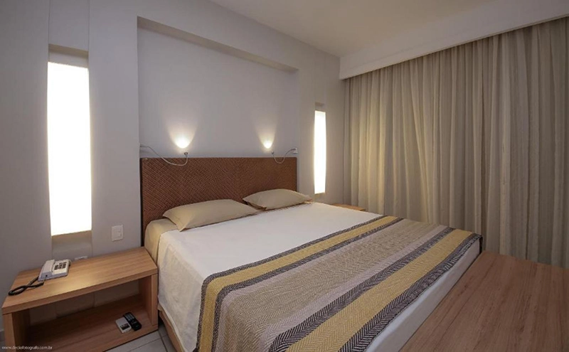 Quarto de hotel com uma cama de casal e uma de solteiro.