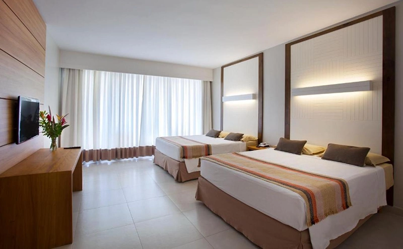 Suíte de hotel espaçosa com cama e sala de estar integrada.